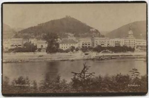 Schandau (Bad Schandau). Blick vom linken Elbufer auf die Stadt mit Elbehotels, Schloßberg und Stadtkirche Johannes der Täufer, am Ufer Schaufelraddampfer "Schandau"