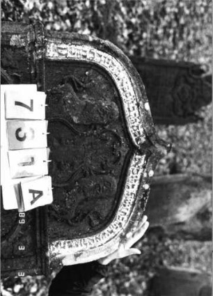 Grabstein 731 (Index: 99751644) Material: Sandstein Zustand: verwittert/Textverlust Maße HxBxT: 142x78x14 cm Beschreibung: Stele, Kielbogenabschluß, rechteckiges Schriftfeld eingetieft Symbolik: Löwenpaar herschauend als Schildhalter, Krone, Girlande, Ranken: Grabstein 731A