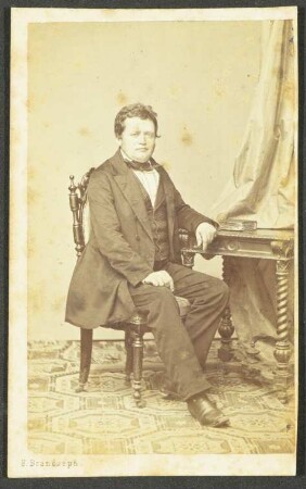 Pfarrer Gustav Hauff sitzend an einem Tisch