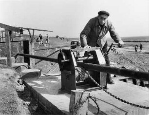 Petkum. Das Tor des Siel´s wird vom Schleusenwärter 1949 noch per Hand bedient.