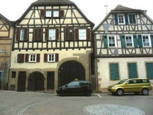 Stadtbild-Kirchplatz - Ansicht im Nordosten mit Gebäudegruppe über Giebelseite-Fachwerkobergeschosse in Riegelbauweise auf steinernem Stock mit Toreinfahrt und Ladeluken
