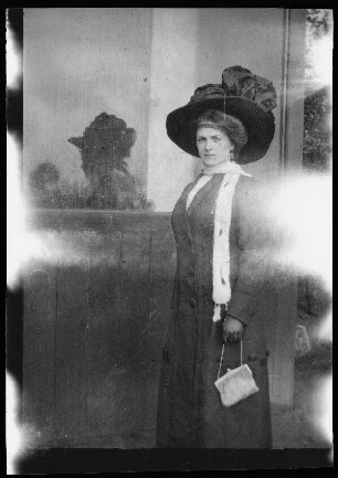 Hamburg: Dame ("nette Hamburgerin, mit der sich Eugen von Frauenholz gut vertrug") vor einer Wand mit Fenster (zum Fotografen blickend)