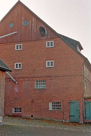 Fritz-Berodt-Straße 7-9: Hofanlage: westliches Wirtschaftsgebäude: rückwärtige Giebelseite, Giebel mit Verbretterung, Abluftrohr und Rundfenstern, unten rechts Stalltür, Toilettenanbau [angeschnitten]