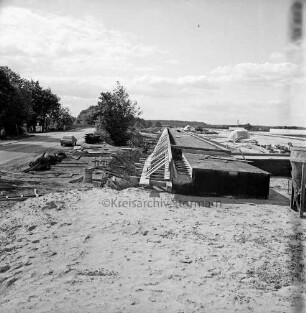 B 75 zwischen Hamberge und Ratzbek: Straßenbau: Bau einer Brücke über die Autobahn A 1: links alte Straßenführung mit Pkw und Bäumen: rechts neue Trasse mit Baumaterial
