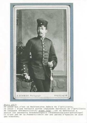 Wachtmeister der badischen Feldartillerie in Uniform, stehend mit aufgestütztem Säbel in Zimmer