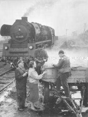Eisenbahner dämpfen mit ihrer Lokomotive zum Einsilieren bestimmte Kartoffeln der LPG Altlüdersdorf (Kr. Gransee)