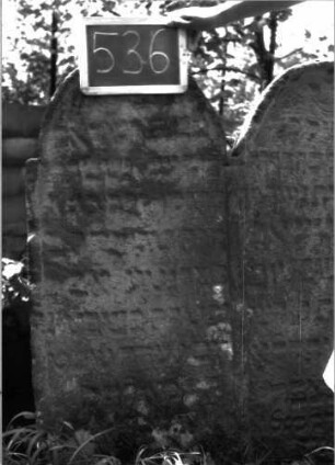 Grabstein 536 (Index: 100102557) Material: Sandstein Zustand: stark verwittert, teilweiser Textverlust Maße HxBxT: 112x100x7 cm Beschreibung: Doppelstele, jeweils eingezogener Rundbogenabschluss, Schriftfeld eingetieft Besonderheit: Doppelgrab für Mutter und Tochter: Grabstein 536 (Detailaufnahme 1)