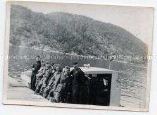 Gruppenbild von Soldaten auf einem Boot an der Kaimauer