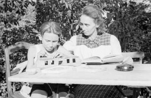Porträt von Walter Dehmel mit Familie im Garten : Frau Dehmel mit Enkelsohn beim Spielen an einem Tisch