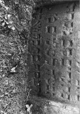 Grabstein 452 (Index: 99752824) Material: Sandstein Zustand: gut, Stele eingesunken Maße HxBxT: 88x66x9 cm Beschreibung: Stele, eingezogener Rundbogenabschluß, Schriftfeld eingetieft Symbolik: Pinienzapfen, Lilie Besonderheit: Zitat Proverbia 12, 4 und 31, 10: Grabstein 452A