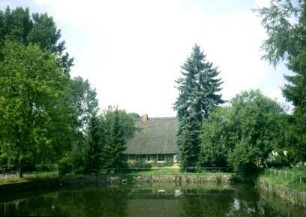Am Teich 7: Kate mit Reetdach: Traufseite: davor Dorfteich