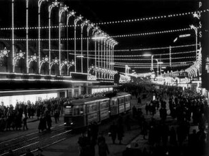 Hamburg-Altstadt. Vorweihnachtlicher Einkaufstrubel auf der Mönckebergstraße, die im Lichterglanz erstrahlt. Besucher strömen aus und in das Kaufhaus Karstadt.