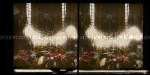 Geschmückter Sarg mit Kränzen und Kerzen in einer Kirche