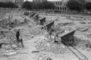 Enttrümmerung im Stadtkern : Dresden-Altstadt. Die Trümmerbahn mit Steinen beladende Frauen und Männer