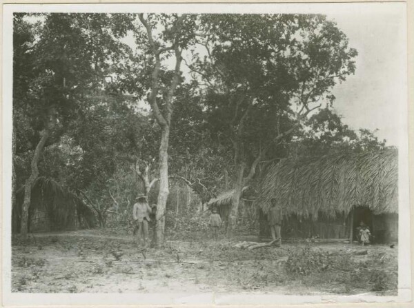 Bakairi Indians in front of a hut