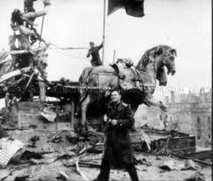 Der Fotograf Jewgeni Chaldej vor der zerstörten Quadriga auf dem Brandenburger Tor