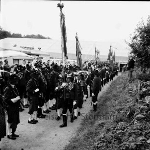 Schützenfest: Veranstalter Schützenverein Reinfeld und Umgebung von 1954 e.V.: Festplatz an der Ahrensböker Straße: Aufmarsch der Tiroler Schützen der Schützenkompanie Wilten (bei Innsbruck) mit Fahnen: rechts Zuschauer auf Böschung: hinten Festzelt mit geöffnetem Eingang, 4. September 1966