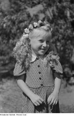 Porträt eines kleinen Mädchens mit Blumenkranz im Haar