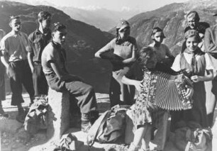 Österreich. Pongau im Salzburger Land. Eine Jugendwandergruppe macht eine Rast. Ein Mitglied der Gruppe spielt Akkordeon