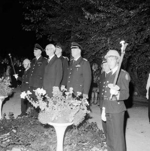 Haarmann, Wennemar: Verabschiedung: Rolfshagener Kupfermühle: Großer Zapfenstreich der Kreisfeuerwehr: Wennemar Haarmann steht auf einem Podest, um ihn herum Feuerwehrleute, dahinter Gäste