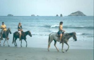 Costa Rica. Touristen hoch zu Roß am Strand