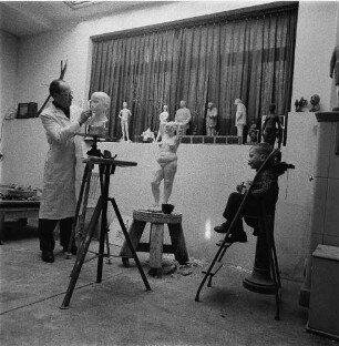ZB-Reportage Kultur. Besuch beim Bildhauer Walter Howard. Der Künstler in seinem Atelier, ein Porträt seines Sohnes modellierend