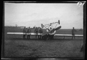 Thines (Provinz Wallonisch-Brabant, Belgien): 6 Soldaten neben einem auf dem Kopf liegenden Propellerflugzeug mit deutscher Luftwaffen-Markierung an den Flügeln ("Tatzenkreuz") ("Notlandung eines deutschen Fliegers bei Thines")
