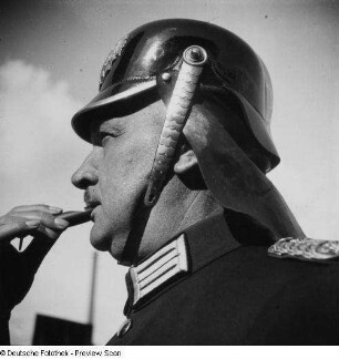 Berliner Feuerwehrmann (Brustbild) mit Helm und Signalpfeife