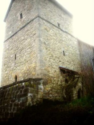 Evangelische Kirche - Kirchturm (gotisch gegründet) von Nordosten mit Schießscharten (Schlitzscharten) in den Mittelgeschossen über Kirchhofmauer