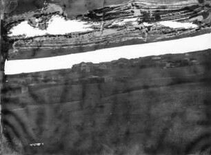 Landschaft mit Siedlung : Blick über Felder auf eine Siedlung.
