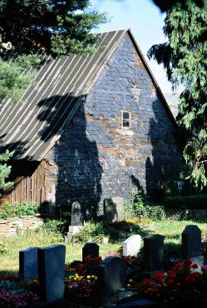 Friedhof mit Gräbern, Mauer, hinten Scheune