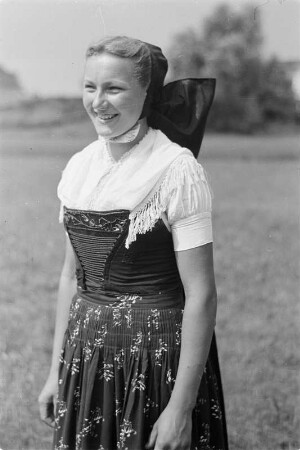 Junge Frau in sorbischer katholischer Ausgehtracht. : Młoda žona w serbskej katolskej wuchodźowanskej drasće.