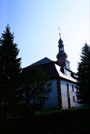 Kirche zwischen Friedhofsbäumen