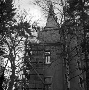 Herrenhaus [Schloss Tremsbüttel]: Teilansicht: Restaurierung der Außenfassade: Türme, Gerüst, Bauplanen, Leitern: beiderseits im Vordergrund Bäume