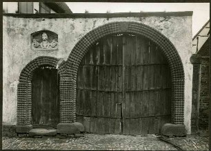 Hauptstr. 72, "Dampfnudel"-Tor. Im Scheitelstein Wappen mit steigendem Pferd, 1716. Über dem Pförtchen Nische mit 3 Köpfen