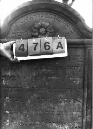 Grabstein 476 (Index: 100115529) Material: Sandstein Zustand: verwittert mit Textverlust Maße HxBxT: 60x42x9 cm Beschreibung: Stele mit eingezogenem Segmentbogenabschluß, eingetieftes, zweigeteiltes Schriftfeld Symbolik: Blüte: Grabstein 476A
