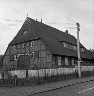 Dorfstraße mit Kopfsteinpflaster: Schullandheim "Heinrich-Sahrhage-Haus": davor Holzzaun: rechts Strommast