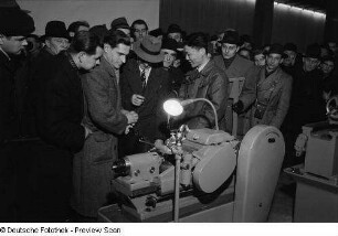 Besucher an einem Messestand mit Maschinen im Ausstellungspavillon von China