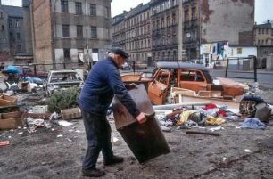 Leipzig, März 1992. Sanierungsgebiet Lindenau. Schrott am Strassenrand, wilde Müllkippe, spielende Kinder