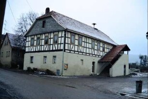 renoviertes Fachwerkhaus mit überdachtem Treppenaufgang; Sirene auf dem Dach