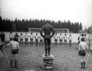 Der nackte Mann auf dem Sportplatz