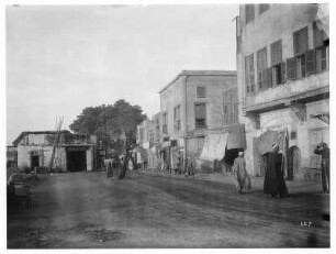 Kairo (Ägypten). Straße mit Einheimischen vor Wohnhäusern