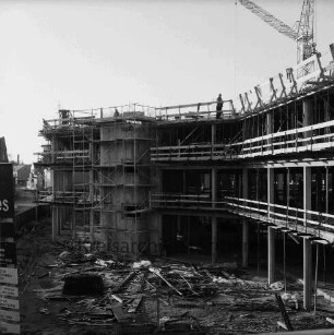 Kreissparkasse Stormarn: Hagenstraße: im Bau mit Bauzaun und Gerüst: Blick von Rathaus auf Baustelle mit Baumaterial und Arbeitern: vorn links Bauschild: dahinter Wohn- und Geschäftshäuser: 19. Dezember 1975