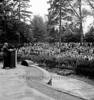 Tag der Deutschen Einheit: Feierstunde: Naturbühne: Bürgerpark: Bezirksverordnetenvorsteher Rudolf Michael aus Berlin-Zehlendorf hält Ansprache am Rednerpult: hinten Zuhörer, 17. Juni 1963