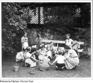 Zwei Frauen mit Vorschulkindergruppe beim "Häschen-in-der-Grube-Spiel" : Villenterrasse. Zwei Frauen mit Vorschulkindergruppe beim "Häschen-in-der-Grube-Spiel"