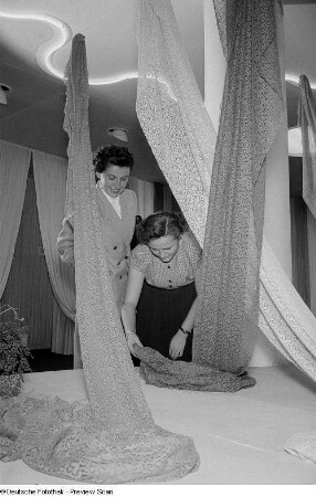 Zwei Frauen begutachten eine Textilie der Leipziger Herbstmesse 1954