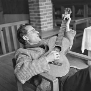 Mann mit Brille spielt Gitarre