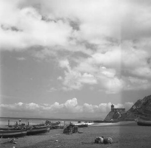 Sizilien, Capo d’Orlando, Blick über den Strand mit Fischerbooten zum Leuchtturm