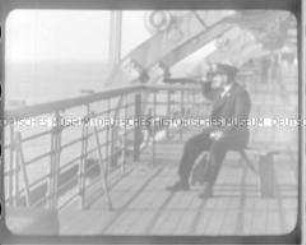Richard Fleischhut an Bord eines Hochseepassagierdampfers ("Bremen" oder "Columbus"), auf einer Holzbank an Deck sitzend