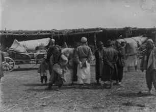 Gruppe vor Pferdewagen : Eine Gruppe aus Zentralasien vor mehreren Pferdewagen im Tian Shan Hochgebirge
